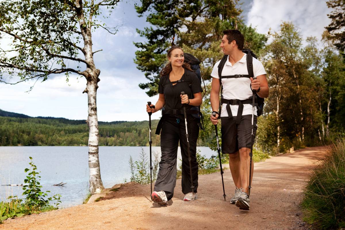 Personne pratiquant la marche nordique avec des bâtons dans une forêt