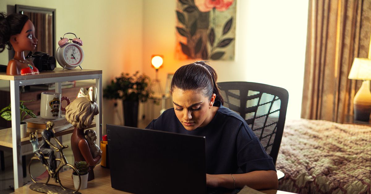 Une femme concentrée travaille sur son ordinateur portable à un bureau épuré