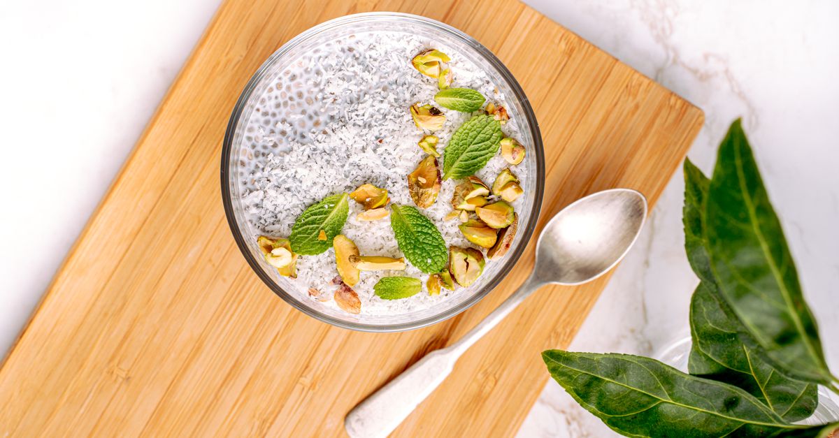 Bol de pudding de graines de chia garni de pistaches et de menthe fraîche