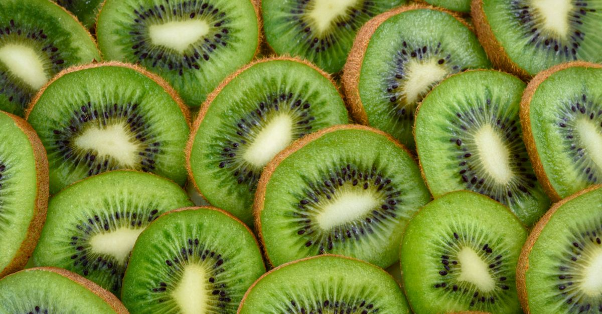 Kiwis entiers et coupés en deux montrant leur chair verte juteuse